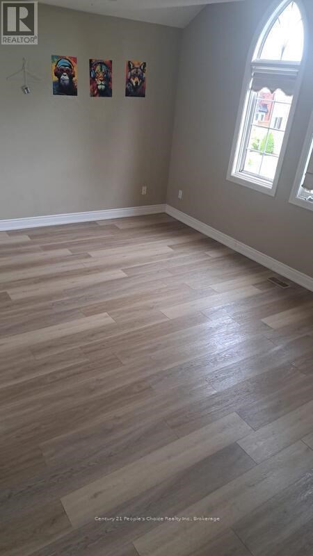 A room with wooden flooring and a window.