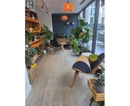 A room with wooden floors and furniture, and a large window.