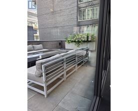 A balcony with a bench and a planter box.