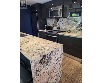 A kitchen with a granite counter top.