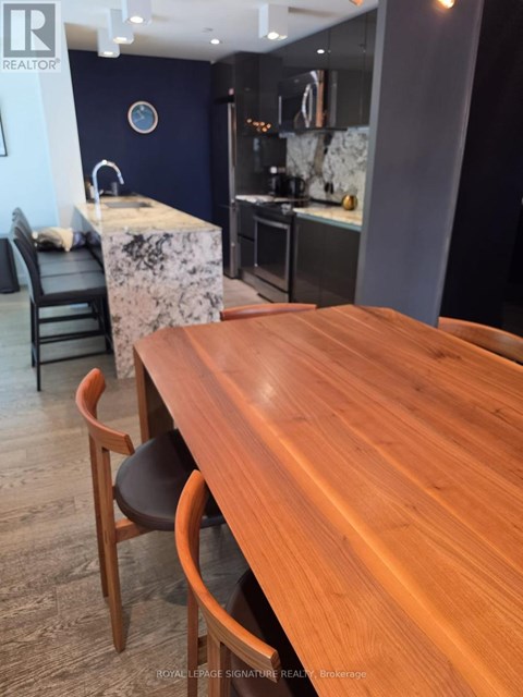 A wooden dining table with chairs in a modern kitchen.