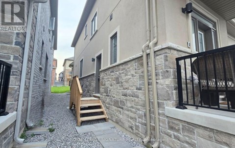A narrow alley with stone walls and a wooden staircase.