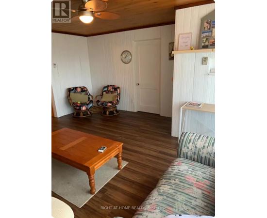A living room with a wooden table and two chairs.