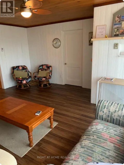 A living room with a wooden table and two chairs.