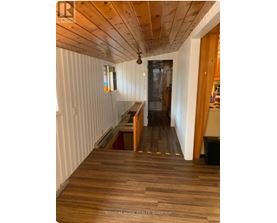 A hallway with wooden floors and white walls.