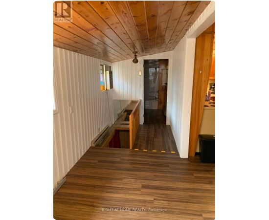 A hallway with wooden floors and white walls.