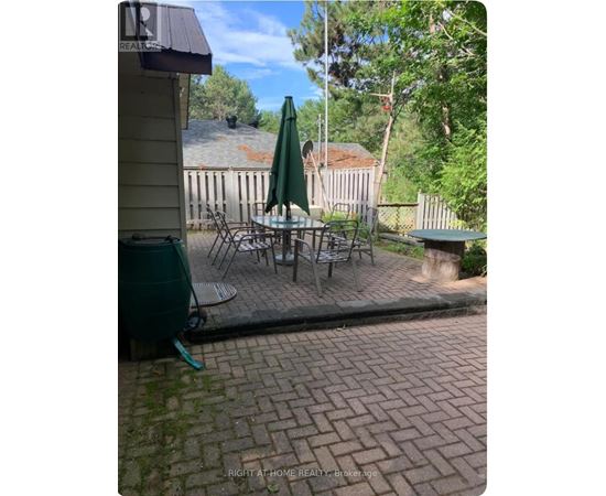 A patio with a table and chairs and an umbrella.