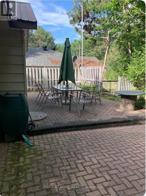 A patio with a table and chairs and an umbrella.