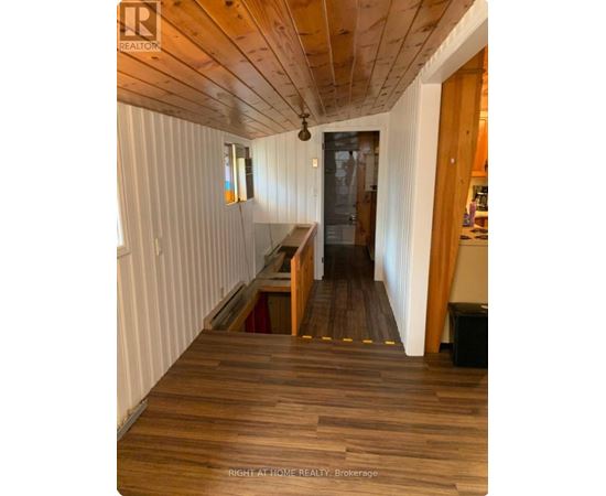 A hallway with wooden floors and white walls.