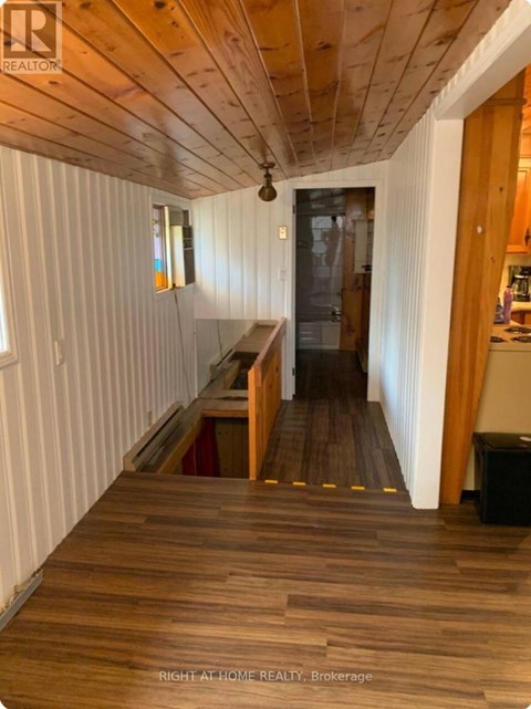 A hallway with wooden floors and white walls.