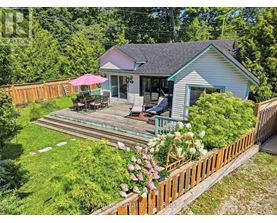 A house with a deck and a pink umbrella.