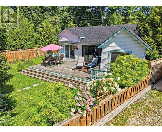 A house with a deck and a pink umbrella.