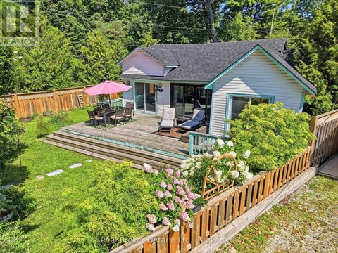 A house with a deck and a pink umbrella.