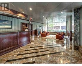 A spacious lobby with marble floors and wooden paneling.