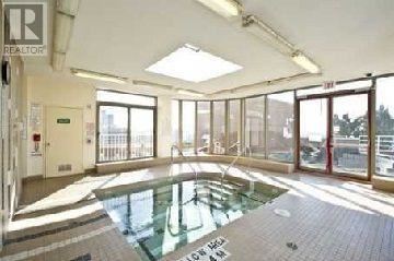 A large indoor swimming pool with a glass ceiling.