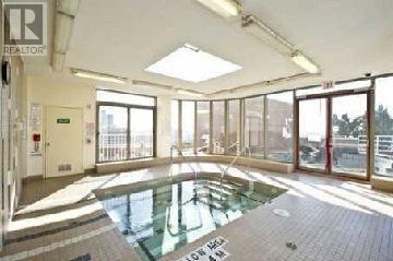 A large indoor swimming pool with a glass ceiling.