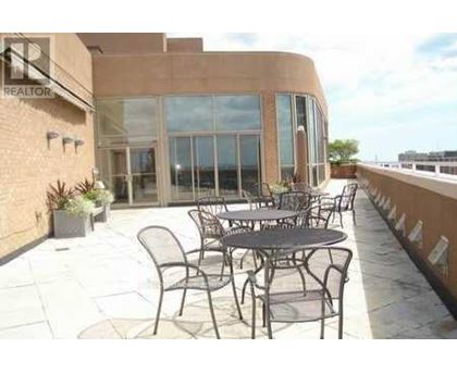 A patio with a table and chairs is in front of a building.