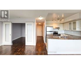 A kitchen with white cabinets and a wooden floor.