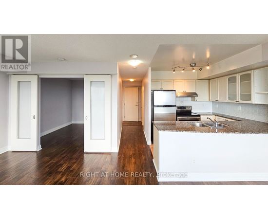 A kitchen with white cabinets and a wooden floor.