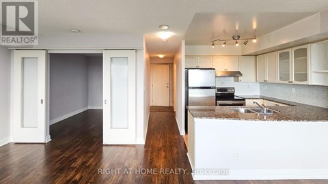 A kitchen with white cabinets and a wooden floor.
