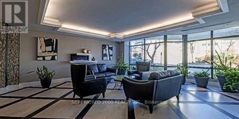 A living room with a black couch and a white coffee table.