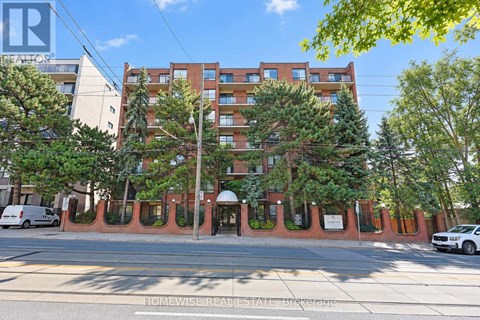 A building with a red brick facade and a white van parked in front.