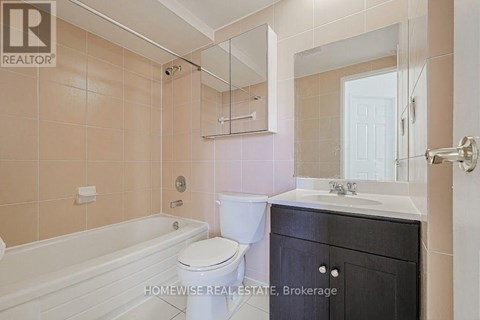 A bathroom with a toilet, sink, and bathtub.