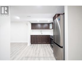 A kitchen with a refrigerator on the right side.
