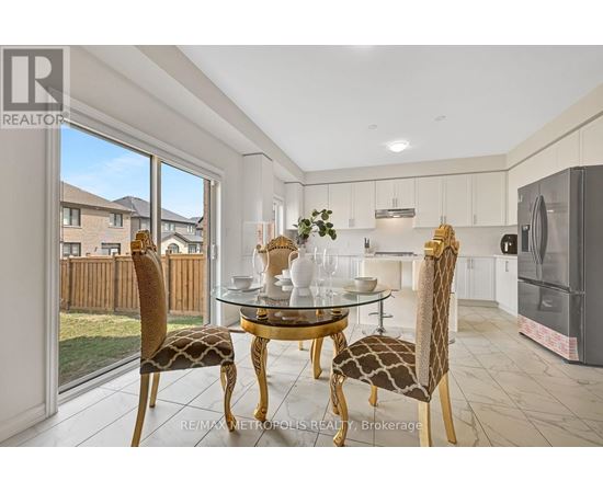 A dining room with a glass table and chairs with a view of a backyard.