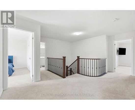A spacious room with a staircase and a flat screen TV.