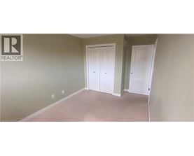 A room with two white doors and a realtor logo on the wall.
