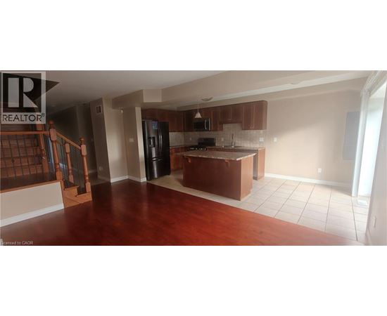 A kitchen with brown cabinets and a black refrigerator.