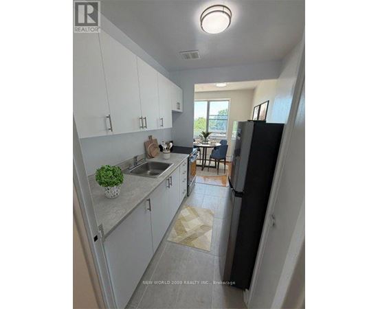 A kitchen with white cabinets and a black refrigerator.