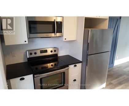 A kitchen with a stove top oven and microwave above it.