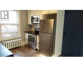 A kitchen with a refrigerator, stove, and oven.