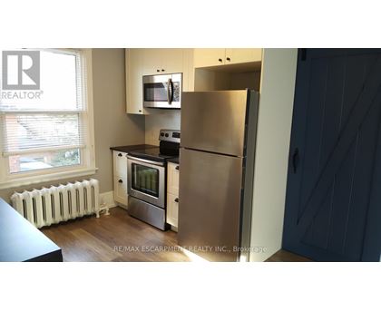 A kitchen with a refrigerator, stove, and oven.
