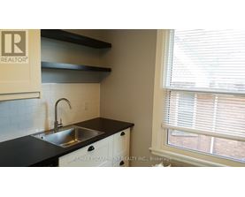 A kitchen with a sink and a window with blinds.