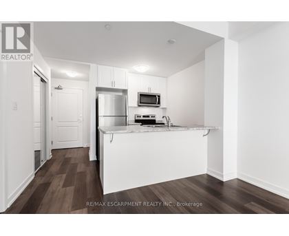 A kitchen with white cabinets and a white island with a microwave on top.