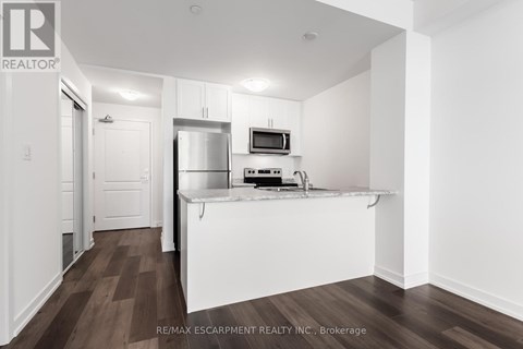 A kitchen with white cabinets and a white island with a microwave on top.