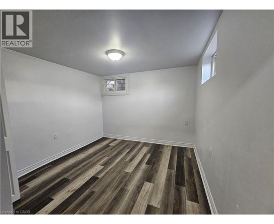 A room with wooden flooring and a window.
