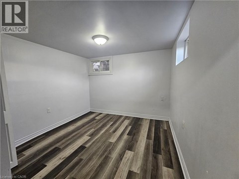 A room with wooden flooring and a window.