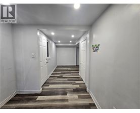 A hallway with wooden flooring and white walls.