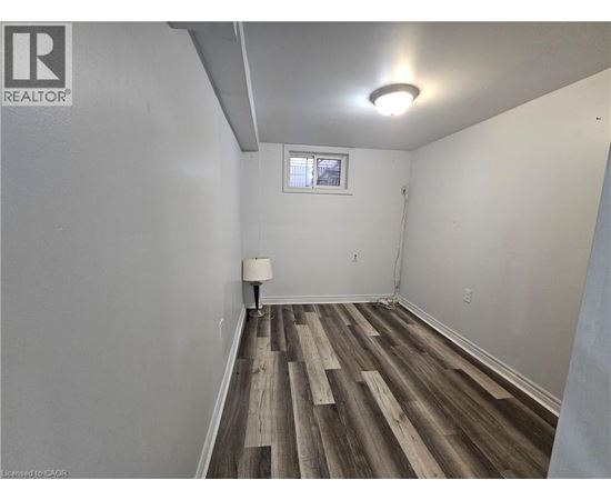 A room with wooden flooring and white walls.