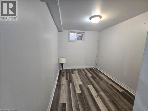 A room with wooden flooring and white walls.
