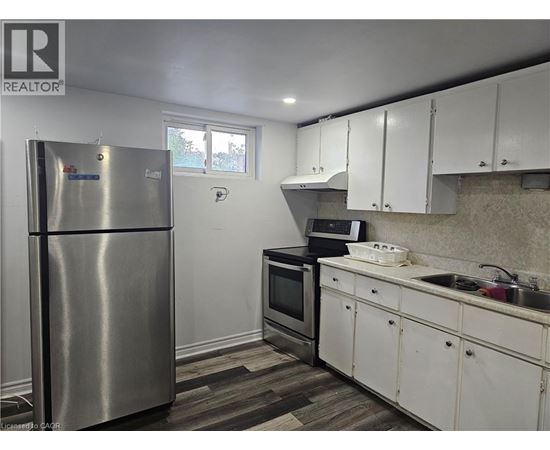 A kitchen with white cabinets and a stainless steel refrigerator.