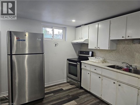 A kitchen with white cabinets and a stainless steel refrigerator.