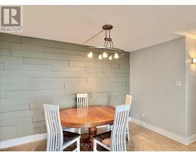 A dining room with a wooden table and chairs.