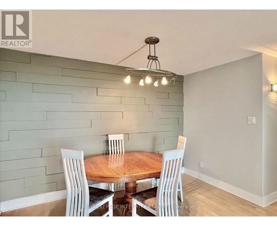 A dining room with a wooden table and chairs.