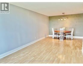 A dining room with a wooden floor and a table with chairs.