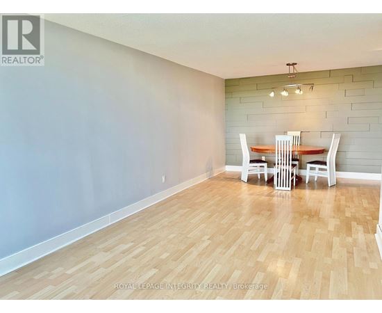 A dining room with a wooden floor and a table with chairs.